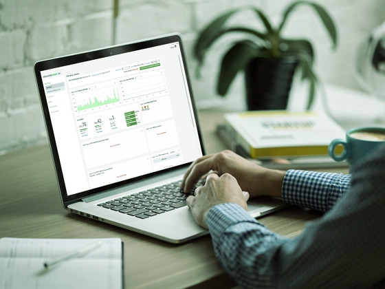 a businessman in front of a laptop with AIONCLOUD dashboard on it